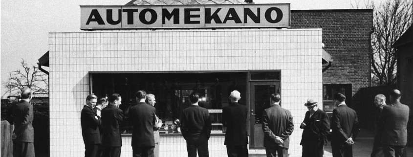 Bilden visar män i kostym som tittar på en verkstad. Kanske tagen på 50-talet.
