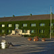 Bilden visa Ifö Sanitärs huvudkontor i Bromölla, en byggnad täckt med växtlighet. Framför huset finns ett torg med en fontän.